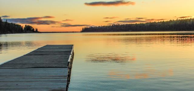 dock on a lake calm waters and sunset